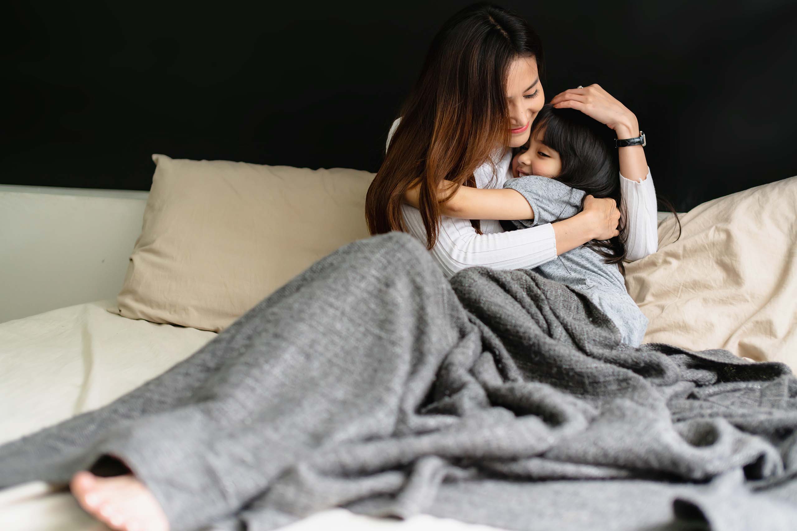 journée internationale des calins : une mère et sa fille qui font un câlin dans un lit
